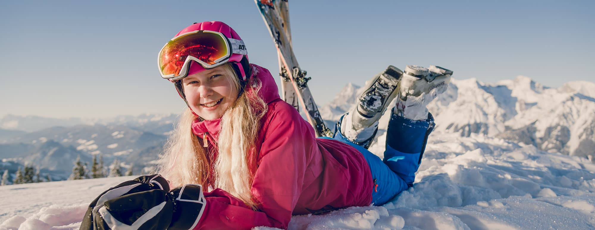 Ein Mädchen im Schnee beim Skiurlaub in der 4-Berge-Skischaukel mit der Planai, Hochwurzen, Reiteralm und dem Hauser Kaibling