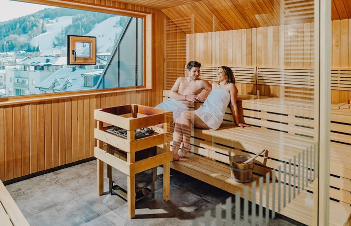 Paar in der finnischen Sauna mit Blick auf die Planai